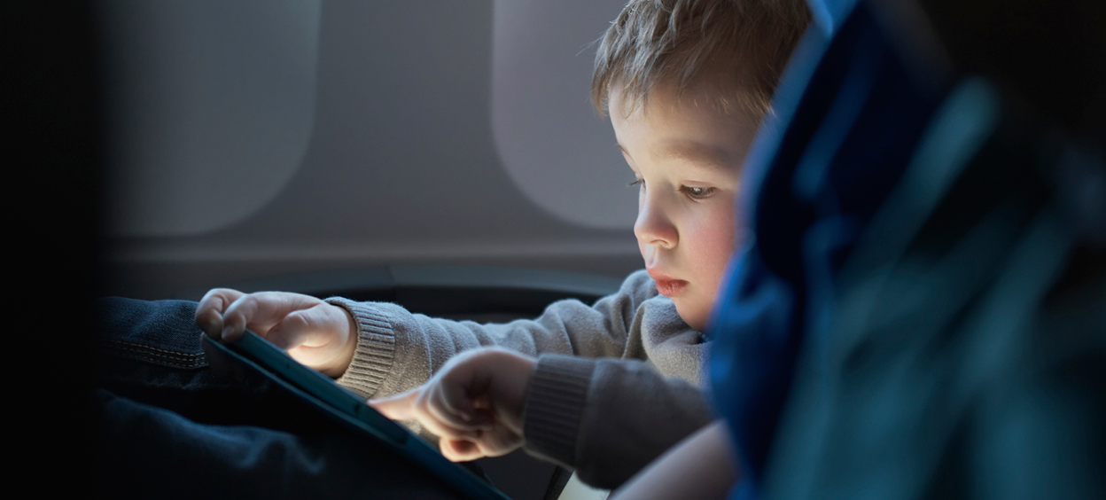 Child using an iPad on airplane